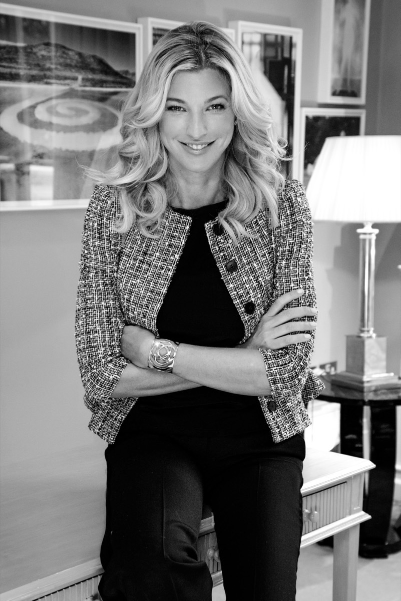 Retrato en blanco y negro de Nicole Junkermann con chaqueta de tweed y brazos cruzados